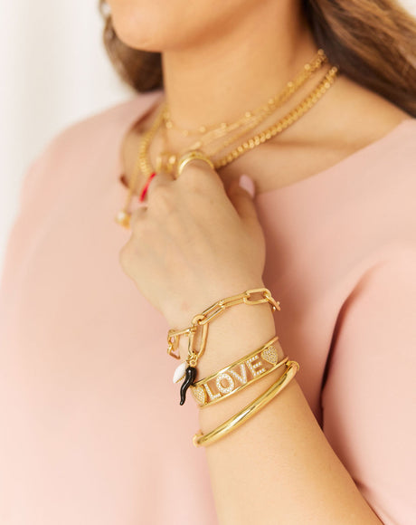 Model wearing the Love Bangle stacked with the Roma bracelet and Colosseum Gold Bangle.
