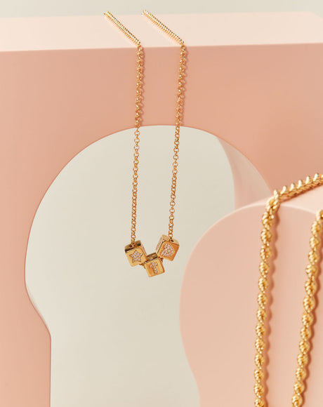 Styled product photography of the Gioci Chain and Dice Pendants.