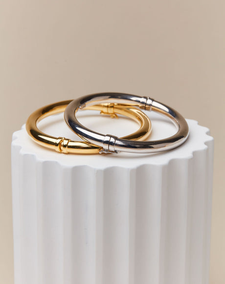 Styled product photography of the Colosseum Gold and Silver Bangle.